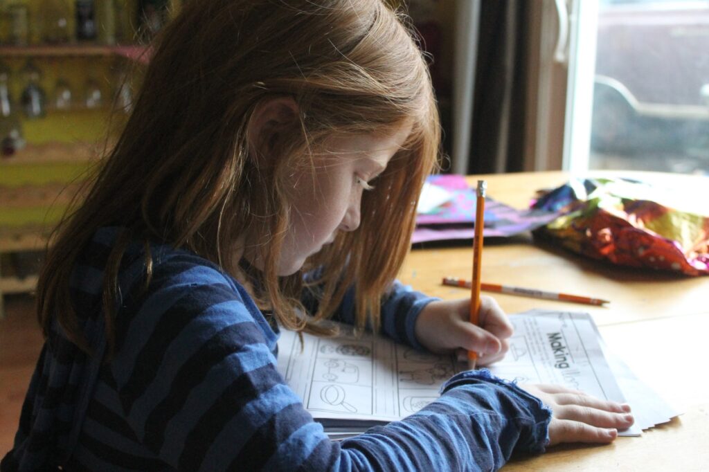 girl drawing on brown wooden table